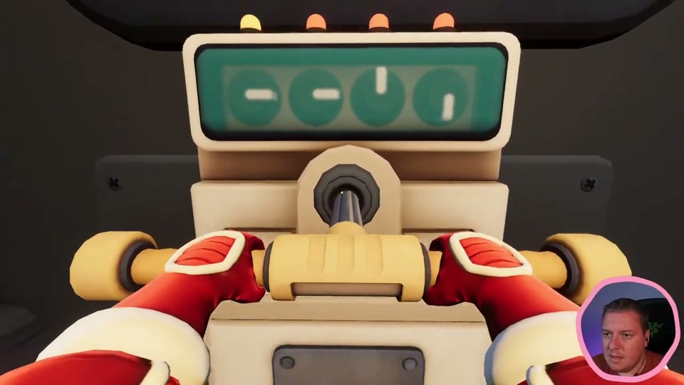 The small player's console inside the machine: a green screen with four round dials and white pointers, four small lamps on top, and a yellow two-handled lever held in red gloves